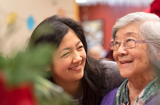 Woman smiling at elderly mother